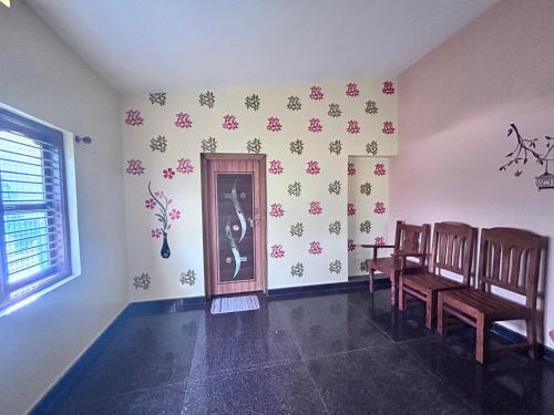 a dining room with flowers on the wall at Shreeniketana stay in Mādangeri