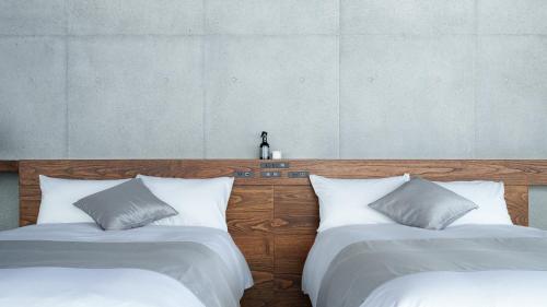 two beds sitting next to each other in a bedroom at Tanegashima Araki Bekkan in Nishinoomote