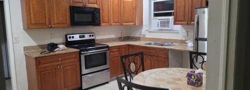 a kitchen with wooden cabinets and a stove top oven at PalmBeachHousefrom69DaylyforPrsmin2PersPPartyP3rRoom in West Palm Beach