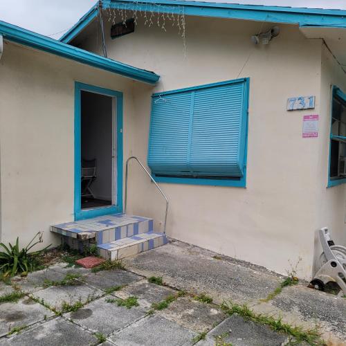 a house with a blue door and stairs in front at PalmBeachHousefrom69DaylyforPrsmin2PersPPartyP3rRoom in West Palm Beach