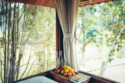 a bowl of fruit sitting on a window sill at Đến Nơi Có Gió - Homestay And Coffee in Hữu Lũng