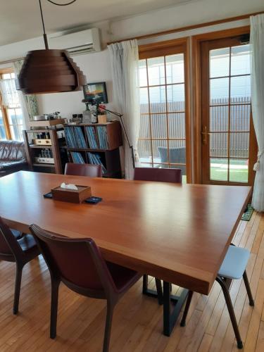 a dining room with a large wooden table and chairs at ゲストハウス苫小牧 202号室 in Tomakomai