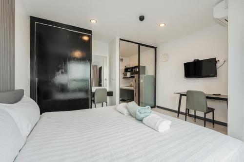 a bedroom with a large white bed with two pillows on it at C237 Brand New 1BR Condo Pool Gym Near Beach in Ban Thalat Choeng Thale
