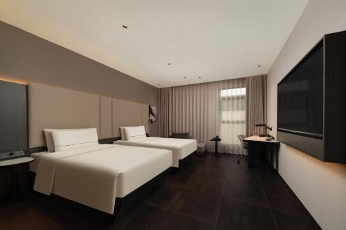 a hotel room with two beds and a flat screen tv at Atour Hotel Shanghai The Bund Yuyuan Subway Station in Shanghai