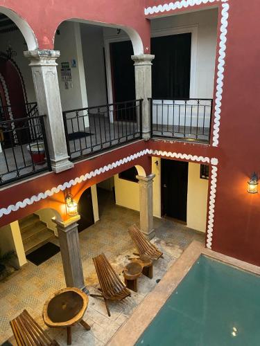 an indoor pool in a building with chairs and a table at Hotel Quinta Marciala MX in Valladolid