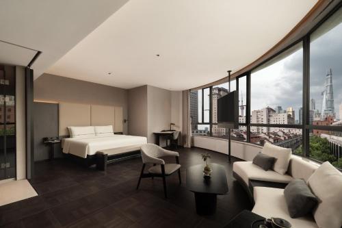 a hotel room with a bed and a couch at Atour Hotel Shanghai The Bund Yuyuan Subway Station in Shanghai