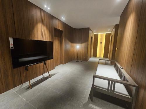 Camera con TV a schermo piatto su una parete in legno di luxury poolvilla second a Pajak