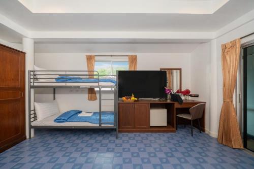a room with two bunk beds and a desk and a television at Oceanview Bungalows by EAT in Karon Beach