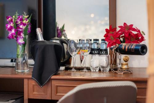 a table with wine glasses and flowers on it at Oceanview Bungalows by EAT in Karon Beach