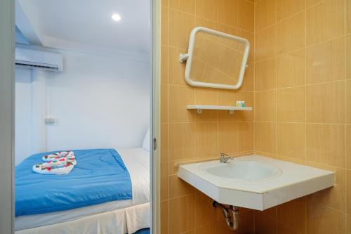 a bathroom with a sink and a bed with a mirror at Oceanview Bungalows by EAT in Karon Beach