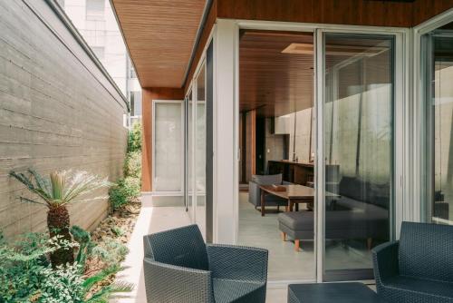 a glass extension of a house with chairs and a table at Tanegashima Araki Bekkan in Nishinoomote