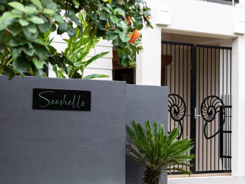 a sign on a wall in front of a gate at 25 Solander Boulevard - Seashells, Port Douglas in Port Douglas