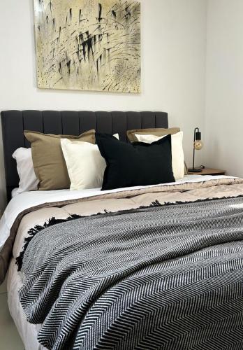 a bedroom with a bed with a black and white comforter at Moderno departamento en el centro de la ciudad in San Fernando del Valle de Catamarca