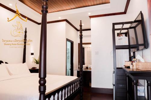 a bedroom with a four poster bed and a mirror at Mueang Nuea Boutique Hotel in Luang Prabang