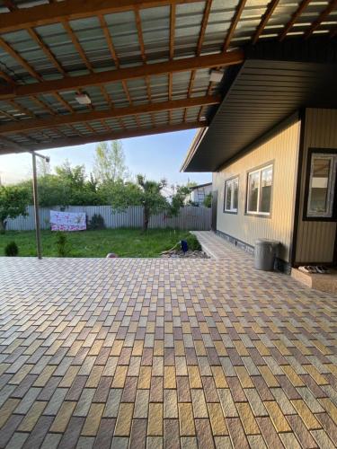 a patio of a house with a roof at Apart Le Mont in Karakol