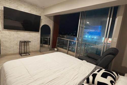 Un dormitorio con una cama y vistas a una ciudad. en Acogedor Loft con ubicación céntrica en Lima, en San Antonio