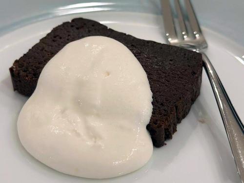 a piece of chocolate cake on a plate with a spoon at THE LAKE Kawaguchiko-kurashi in Fujikawaguchiko