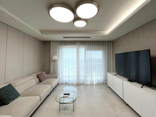 a living room with a couch and a flat screen tv at SoYou osiria residence in Busan