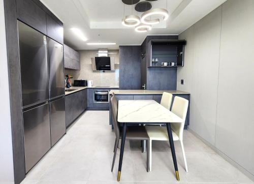 a kitchen with a table and chairs and a refrigerator at SoYou osiria residence in Busan