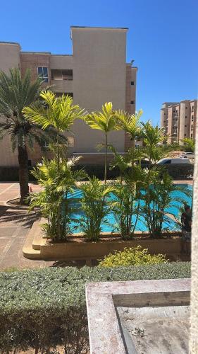 a resort with palm trees and a swimming pool at Lujoso apartamento vacacional in Porlamar