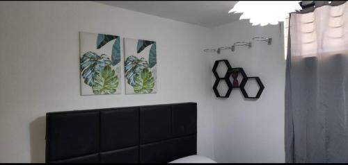 a living room with a tv and two pictures on the wall at Lujoso apartamento vacacional in Porlamar