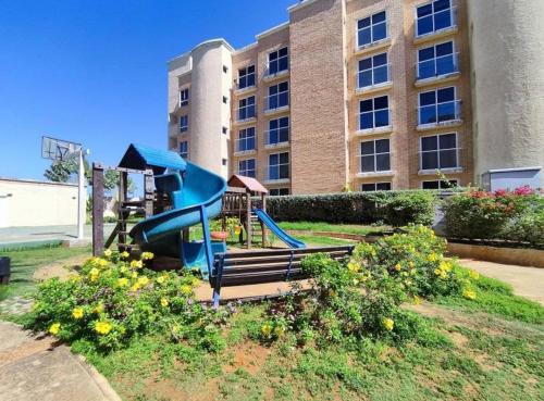 a playground with a slide in front of a building at Lujoso apartamento vacacional in Porlamar
