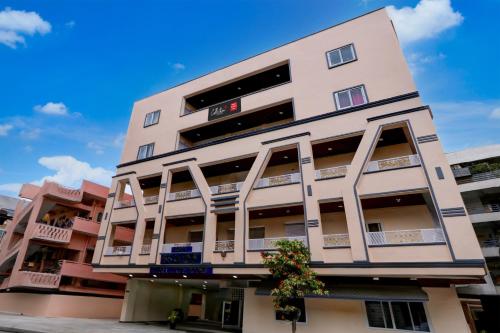 a tall pink building with balconies on it at Hotel O Ss ome inn ultra luxury rooms in Ameerpet