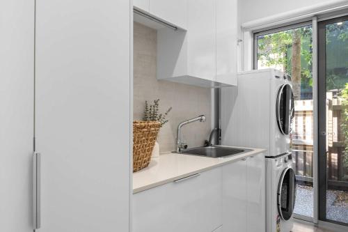 a kitchen with a sink and a refrigerator at Casa al mare - Bribie Island 5BD Retreat in Woorim