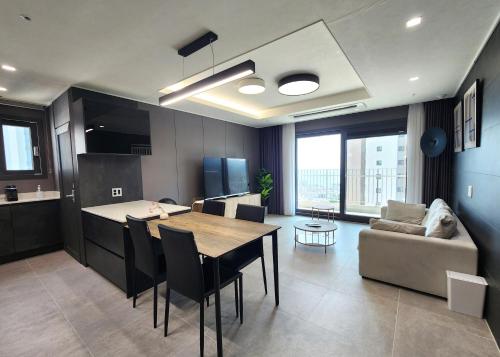 a kitchen and living room with a table and a couch at SoYou osiria residence in Busan