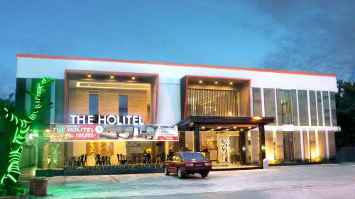 a building with a car parked in front of it at Holitel Hotel in Pekanbaru