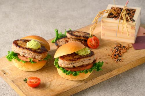 a wooden cutting board with three sandwiches on it at Grand Mercure Nara Kashihara in Kashihara