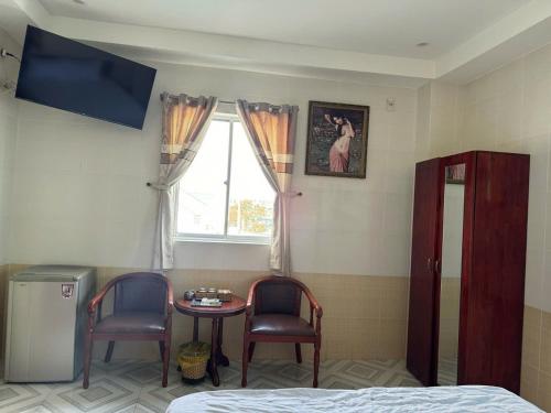 a room with a table and two chairs and a window at Thành Đạt Hotel Bạc Liêu in Bạc Liêu