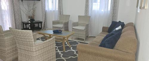 a living room with chairs and a table and a couch at Beachfront Habitat in Flic-en-Flac