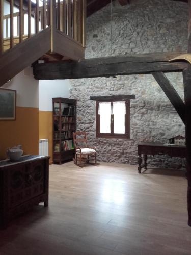 a living room with a stone wall and a piano at Otardi in Asteasu