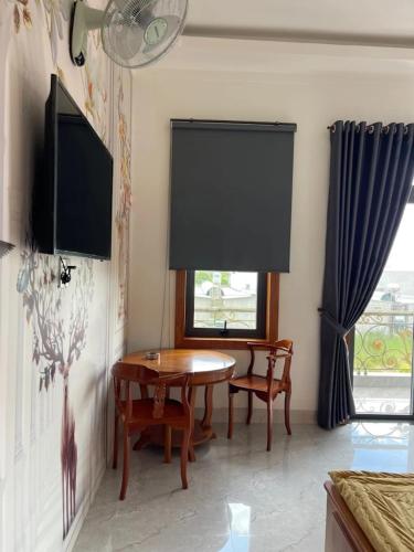 a dining room with a table and chairs and a window at Khách Sạn An Nhiên in Bến Cát