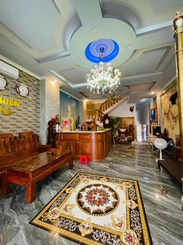 a living room with a chandelier and a rug at Khách Sạn An Nhiên in Bến Cát