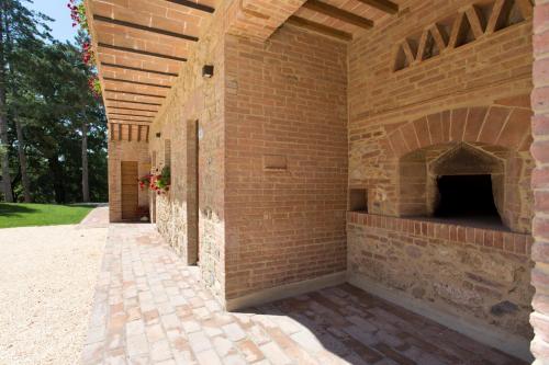 an outdoor brick wall with a brick fireplace at Casale San Galgano in Chiusdino
