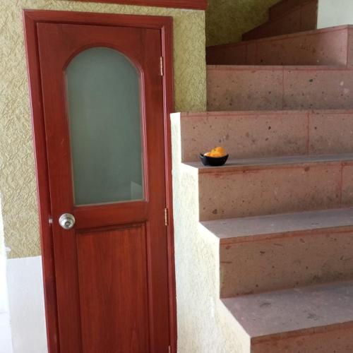 a staircase with a wooden door with a bowl on it at Casa Cielo Lindavista in Tulancingo
