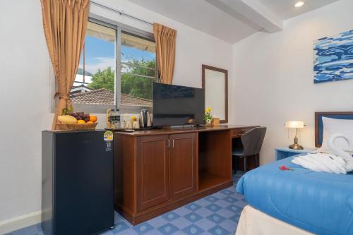 a hotel room with a desk and a bed at Oceanview Bungalows by EAT in Karon Beach