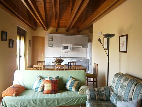 sala de estar con sofá verde y cocina en Casa Miguel Périz, en Sorripas