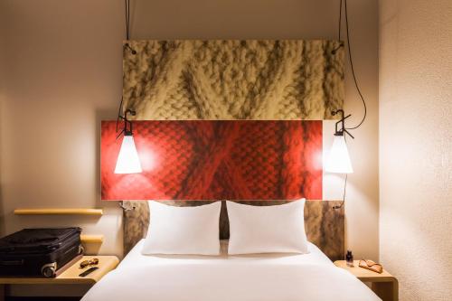 a bedroom with a bed and a lamp at ibis Winterthur City in Winterthur