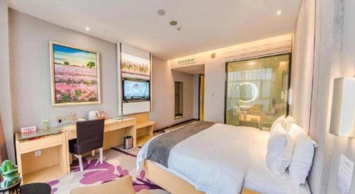 a bedroom with a bed and a desk and a computer at Lavande Hotel Yichang Railway East Station Branch in Yichang