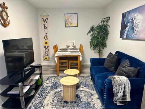 a living room with a blue couch and a table at Global Family Canada in Calgary