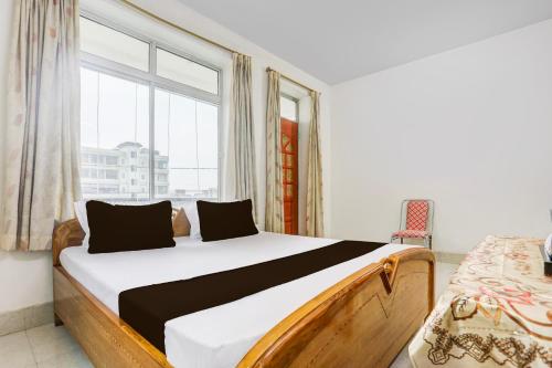 a bedroom with a bed and a large window at Hotel O Stay Inn & Restaurant in Gulzārbāgh