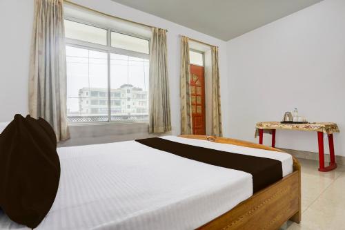 a bedroom with a large bed and a large window at Hotel O Stay Inn & Restaurant in Gulzārbāgh