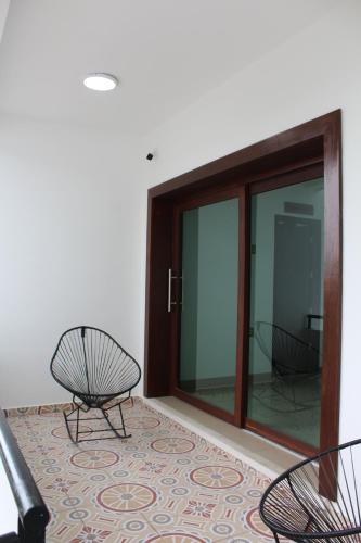 a room with two chairs and a glass door at Hotel Monkey House Tuxtla Gutiérrez in Tuxtla Gutiérrez