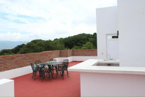a patio with a table and chairs on a balcony at Hotel Monkey House Tuxtla Gutiérrez in Tuxtla Gutiérrez