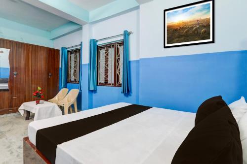 a bedroom with a large bed with blue walls at Hotel O Raj in Dānāpur