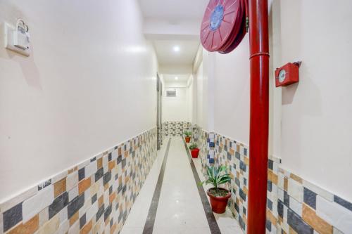 a hallway with tiles on the wall and a clock at Hotel O S G H INN in Kakarmatha