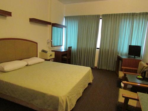 a hotel room with a bed and a television at Hotel Supreme in Singapore